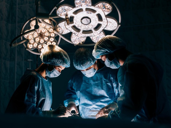 Surgeons in a medical setting wearing scrubs with dramatic lighting
